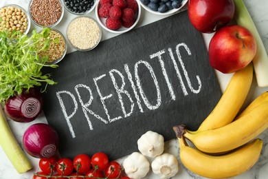 Photo of Slate board with word Prebiotic and different fresh products on white table, flat lay