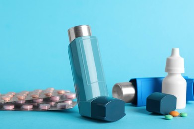 Photo of Different asthma medications on light blue background, closeup