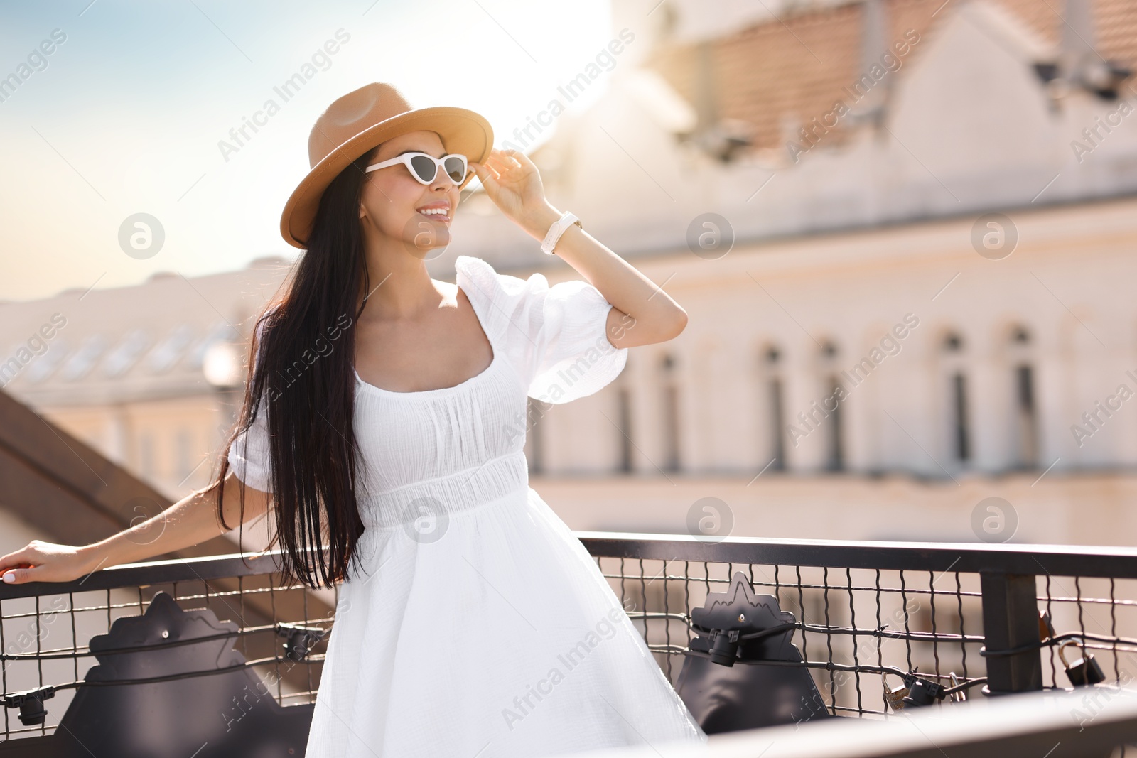 Photo of Smiling woman in stylish hat and sunglasses on city street