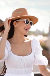 Photo of Smiling woman in stylish hat and sunglasses outdoors