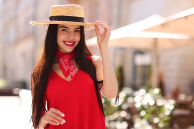 Beautiful young woman in stylish hat on city street, space for text