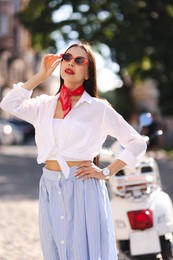 Photo of Young woman in stylish sunglasses on city street