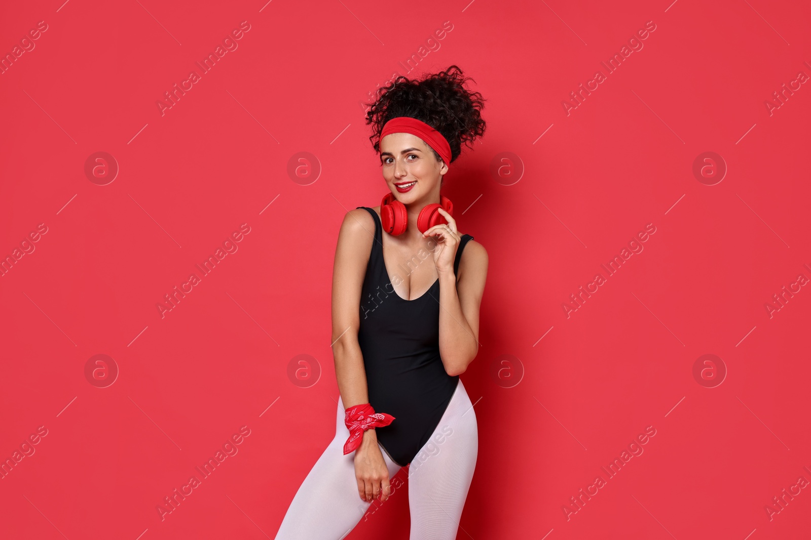 Photo of Aerobics. Happy woman with headphones on red background