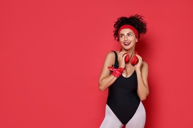 Aerobics. Happy woman with headphones on red background, space for text