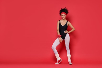 Photo of Aerobics. Happy woman in sportswear on red background