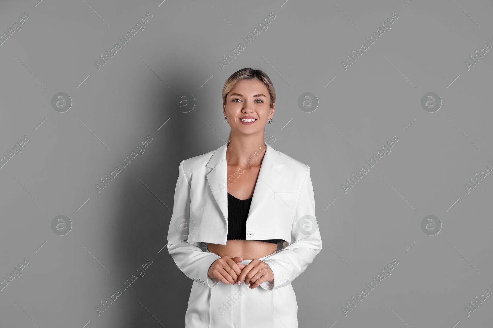 Photo of Beautiful woman in stylish white suit on grey background