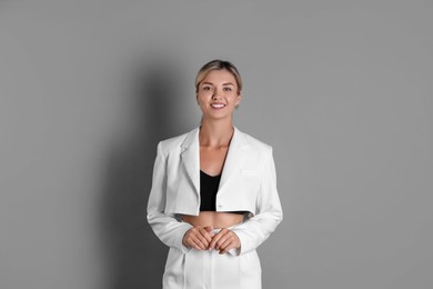 Photo of Beautiful woman in stylish white suit on grey background