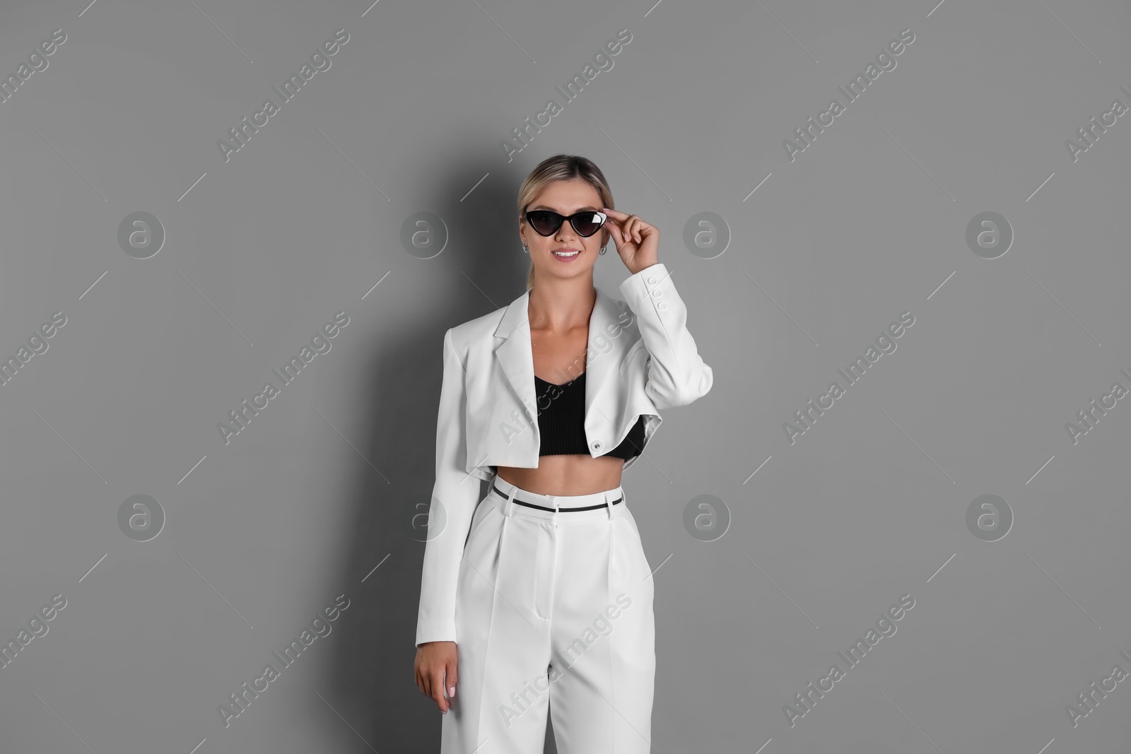 Photo of Beautiful woman in stylish white suit on grey background