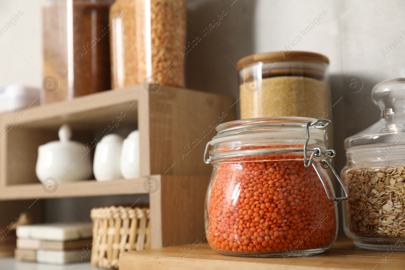 Photo of Different types of cereals and legumes in containers on table, closeup. Space for text