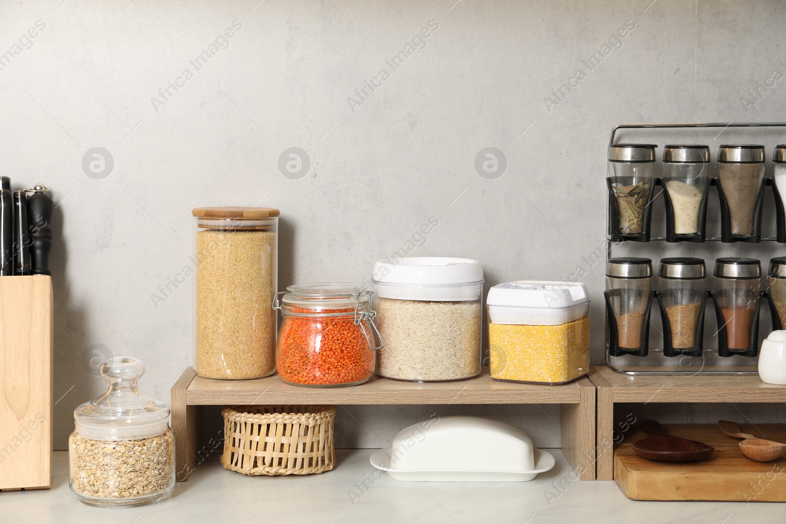 Photo of Different types of cereals and legumes in containers on light marble table