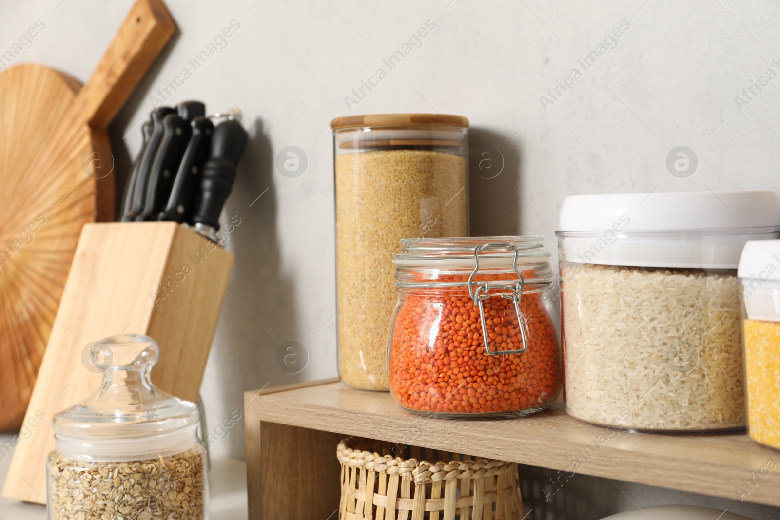 Photo of Different types of cereals and legumes in containers on light table