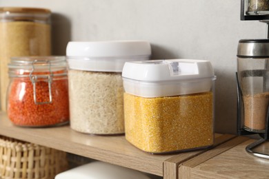 Photo of Different types of cereals and legumes in containers on light table