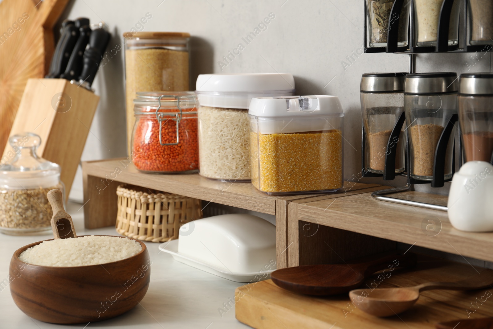 Photo of Different types of cereals and legumes in containers on light table