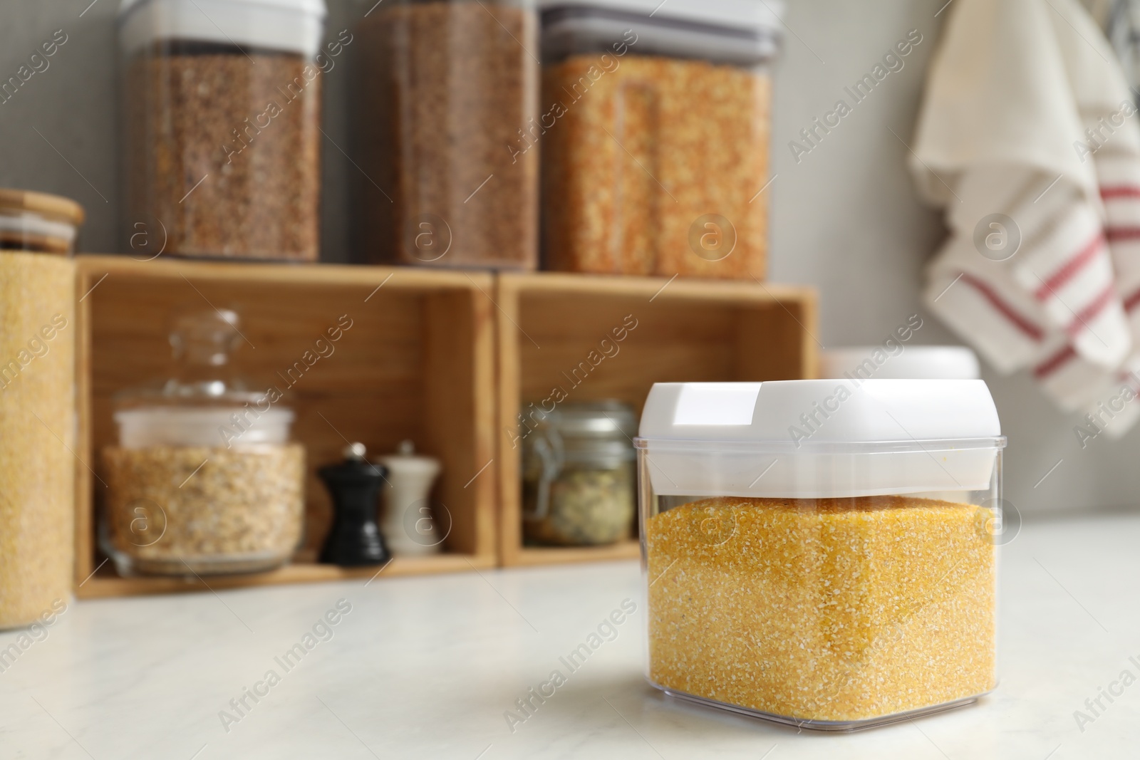 Photo of Different types of cereals in containers on light marble table, space for text