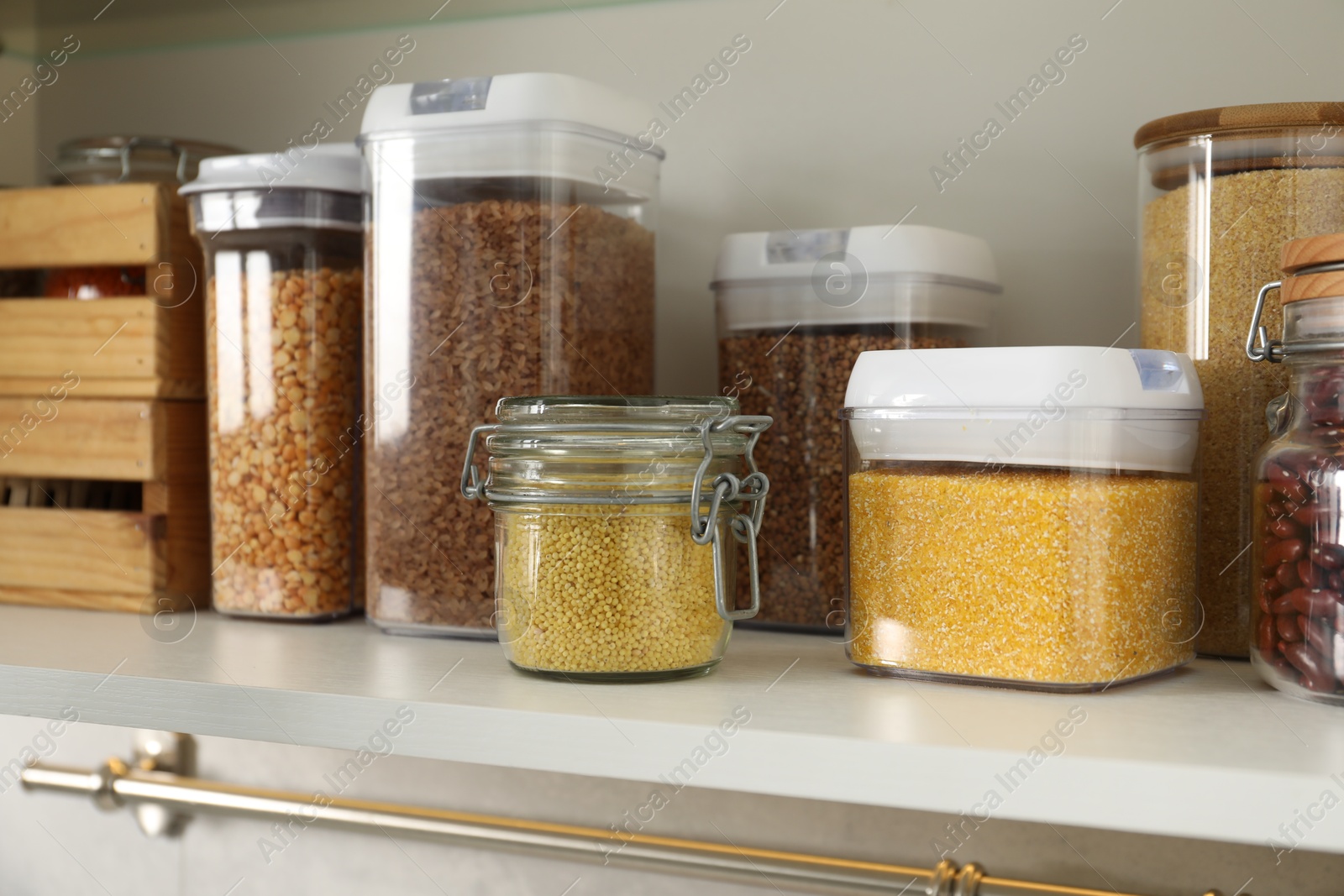 Photo of Different types of cereals and legumes in containers in kitchen