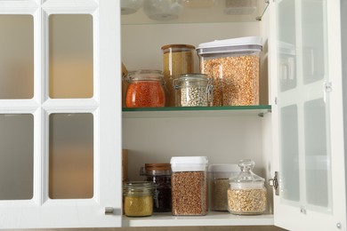 Photo of Different types of cereals and legumes in containers in kitchen