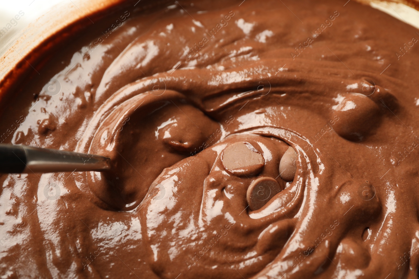 Photo of Melting chocolate chips for dough in bowl, closeup