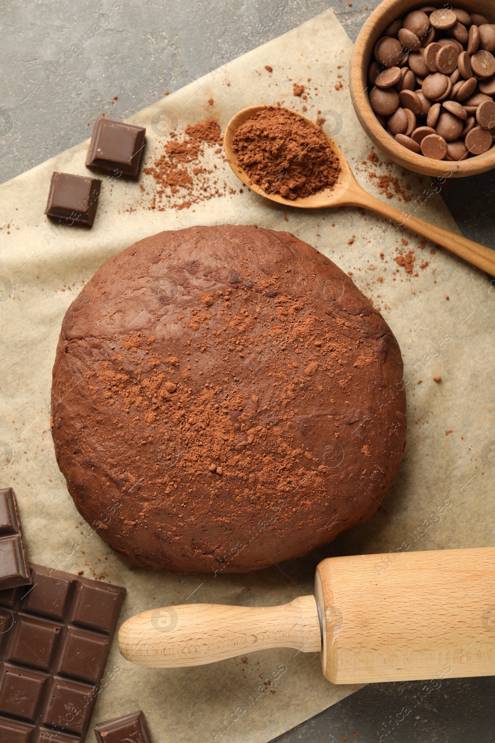 Photo of Chocolate dough and ingredients on grey table, flat lay