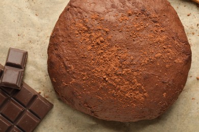 Photo of Chocolate dough and ingredients on parchment, closeup