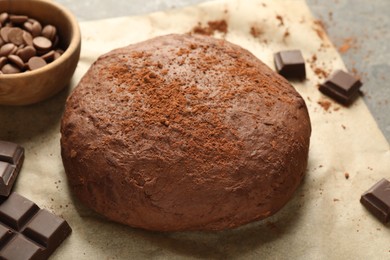 Photo of Chocolate dough and ingredients on grey table, closeup