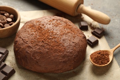 Photo of Chocolate dough and ingredients on grey table, closeup