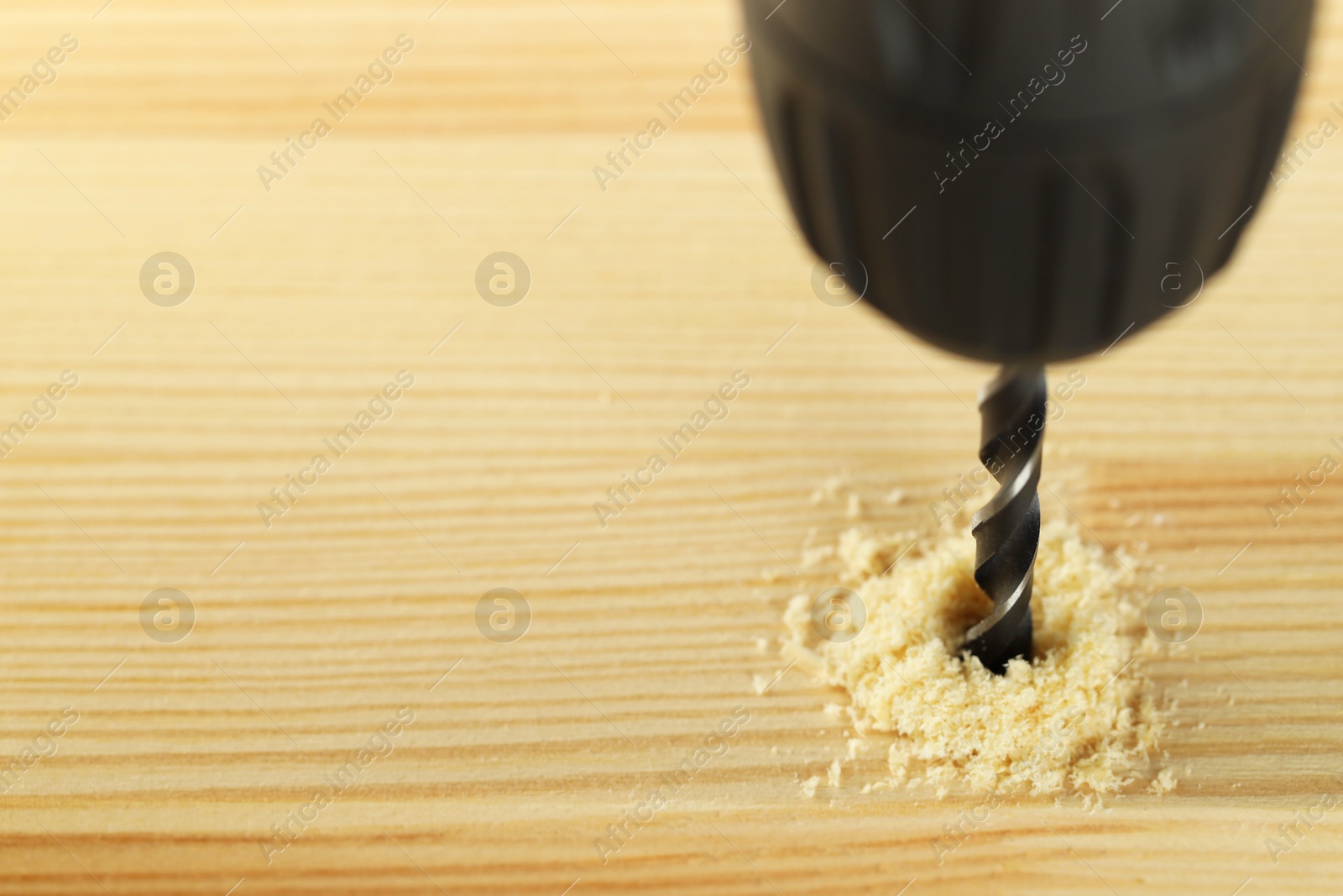 Photo of Drilling hole in wooden plank, closeup. Space for text