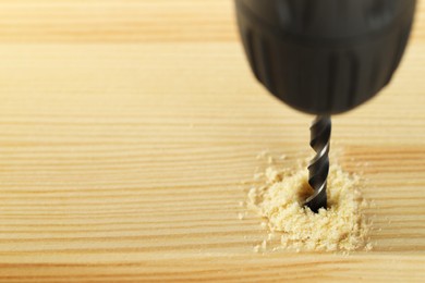 Photo of Drilling hole in wooden plank, closeup. Space for text