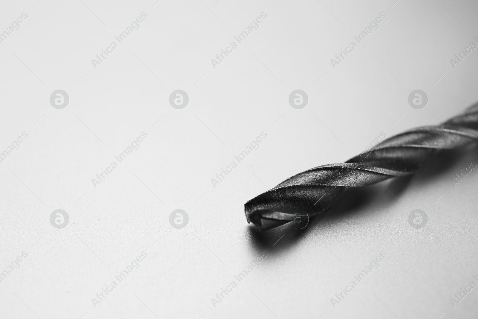 Photo of One drill bit on light grey background, space for text