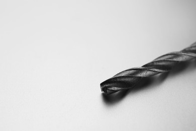 Photo of One drill bit on light grey background, space for text