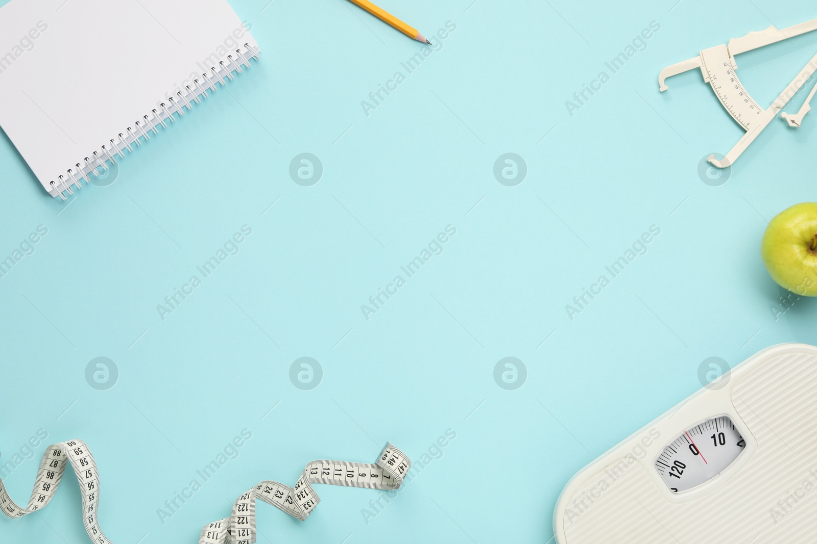 Photo of Flat lay composition with body fat caliper and measuring tape on light blue background. Space for text