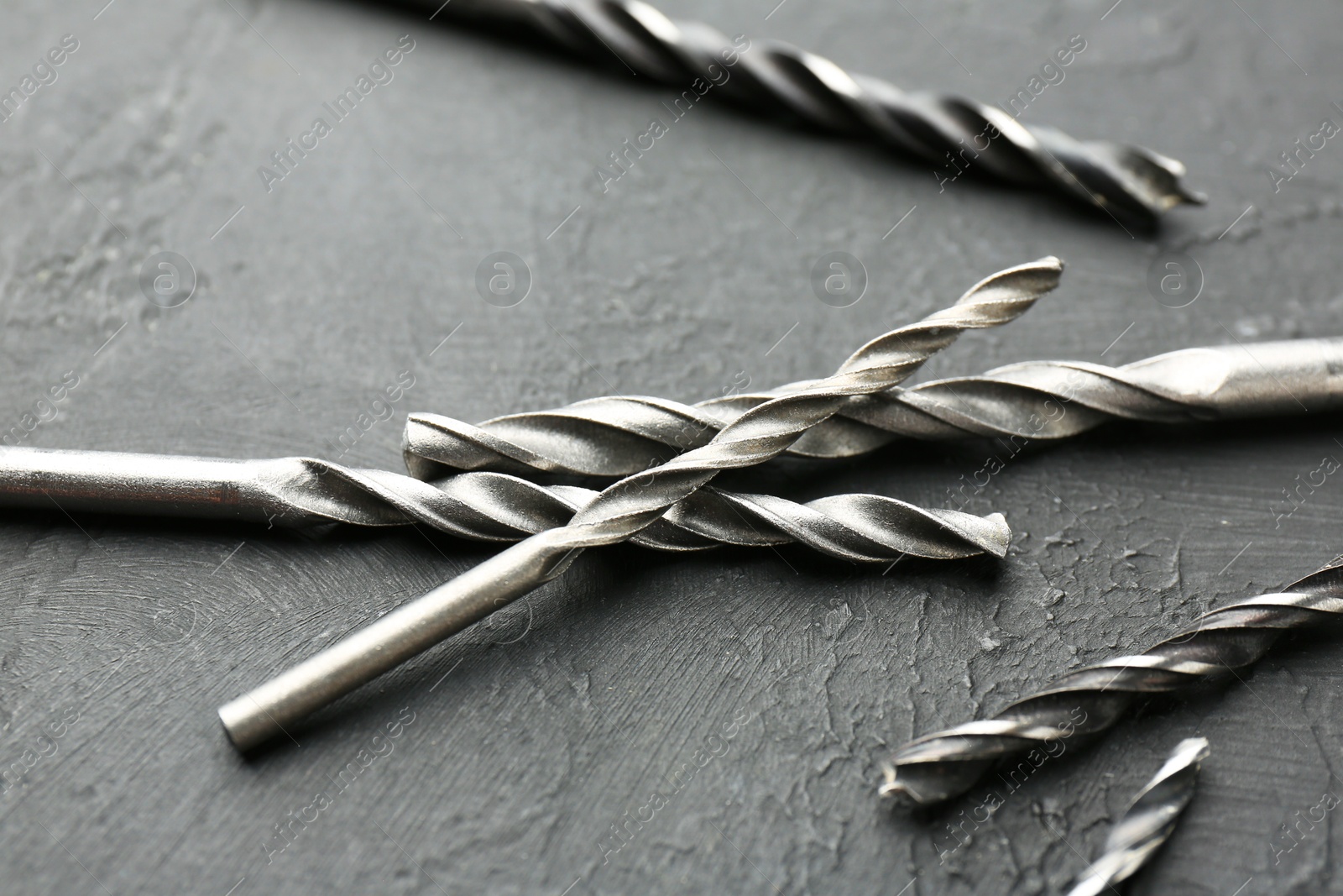 Photo of Many different drill bits on grey table, closeup