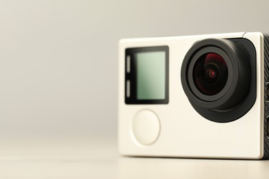 Modern action camera on light background, closeup. Space for text