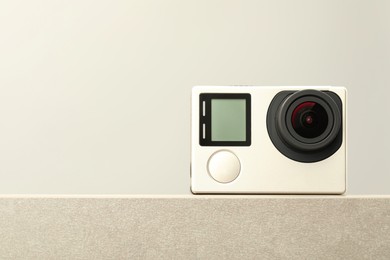 Modern action camera on stone surface, closeup. Space for text