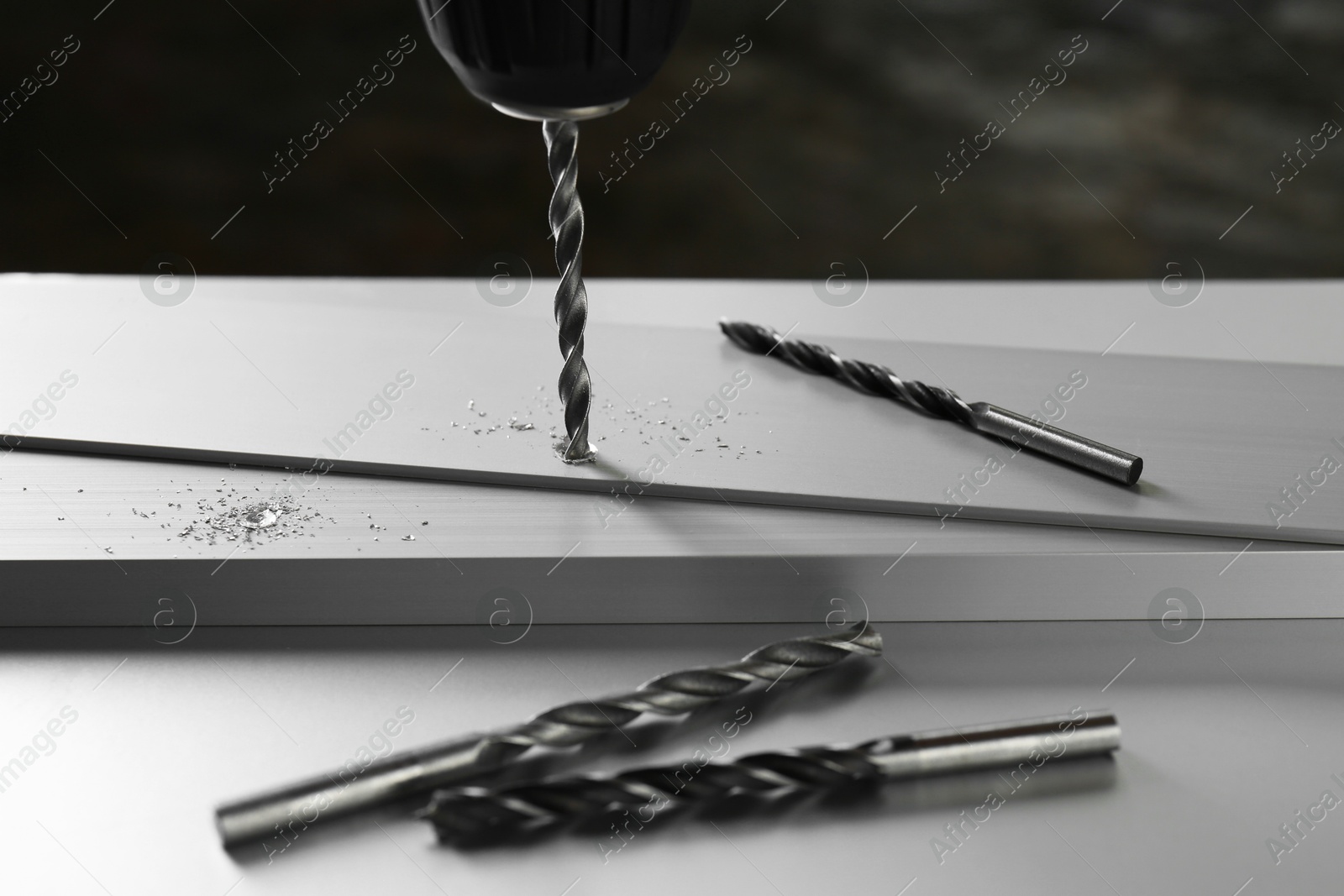 Photo of Drilling hole in plank on light table, closeup