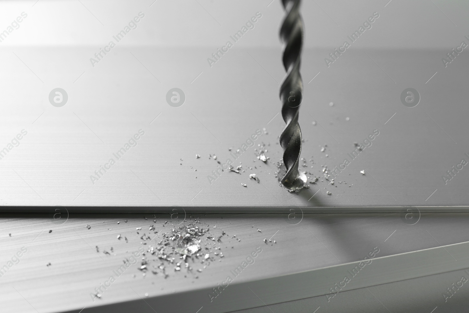 Photo of Drilling hole in plank on light table, closeup