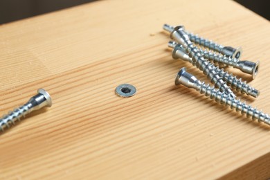 Photo of Many screws and wooden plank, closeup view