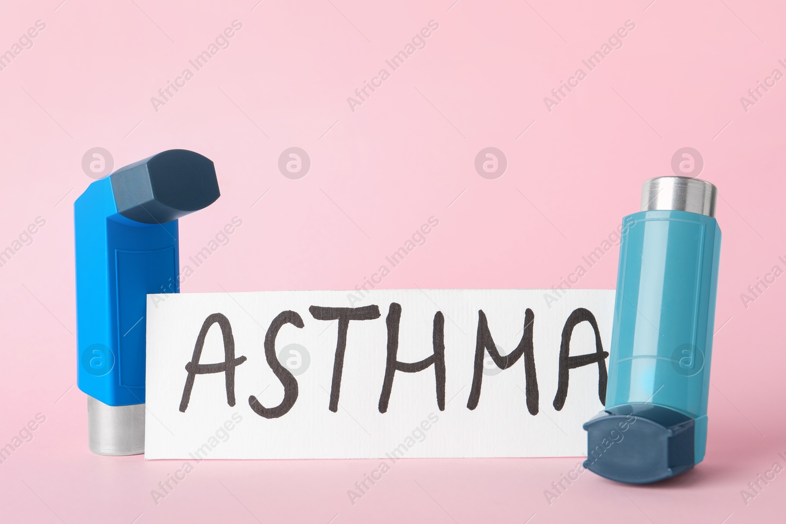 Photo of Card with word Asthma and inhalers on pink background, closeup