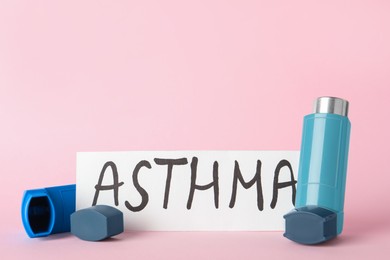 Photo of Card with word Asthma and inhalers on pink background, closeup