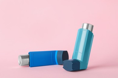 Photo of Inhalers on pink background, closeup. Asthma treatment