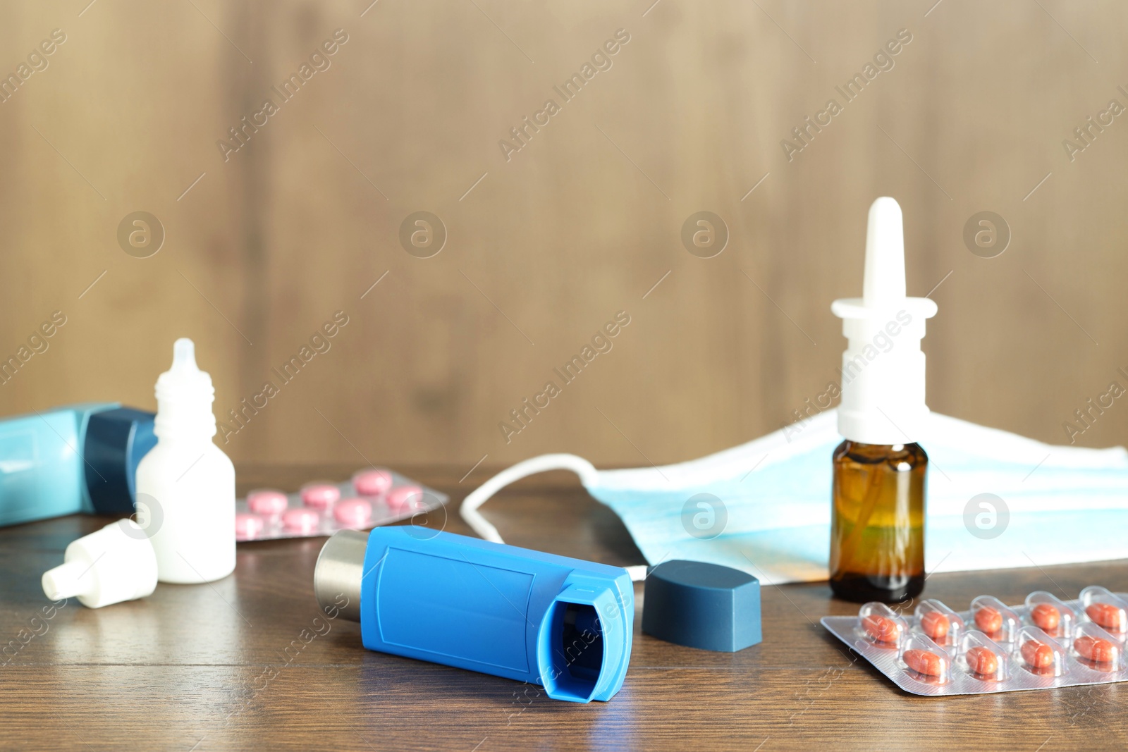 Photo of Different asthma medications on wooden table indoors, closeup