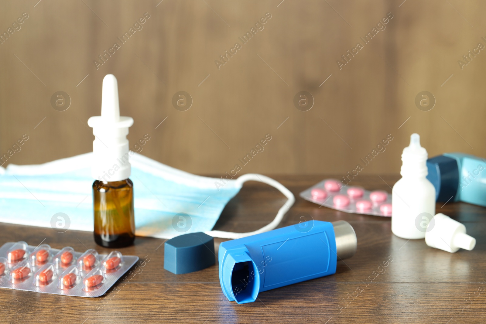 Photo of Different asthma medications on wooden table indoors, closeup