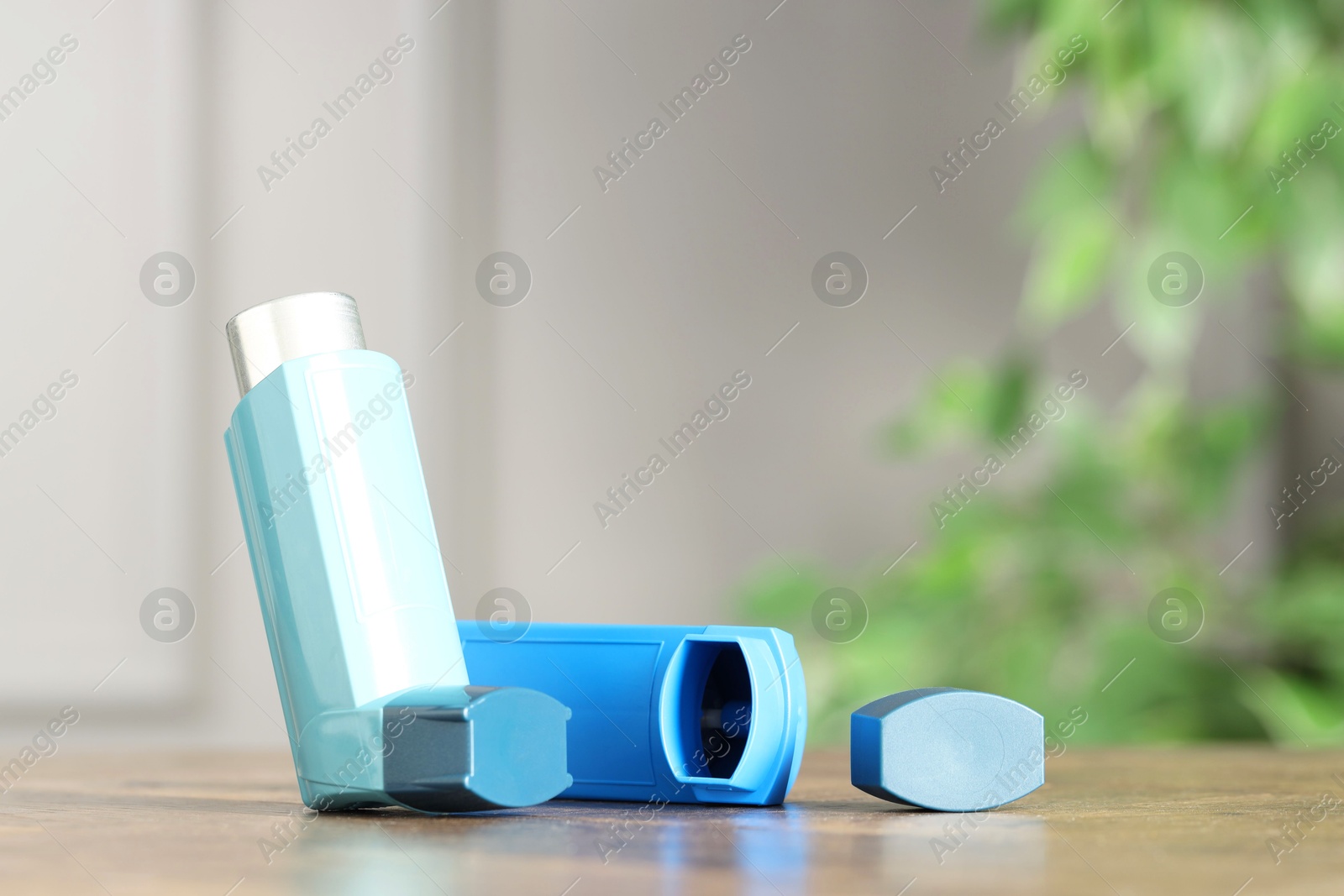 Photo of Inhalers on wooden table indoors, closeup with space for text. Asthma treatment