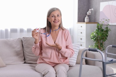 Happy senior woman with emergency call button at home