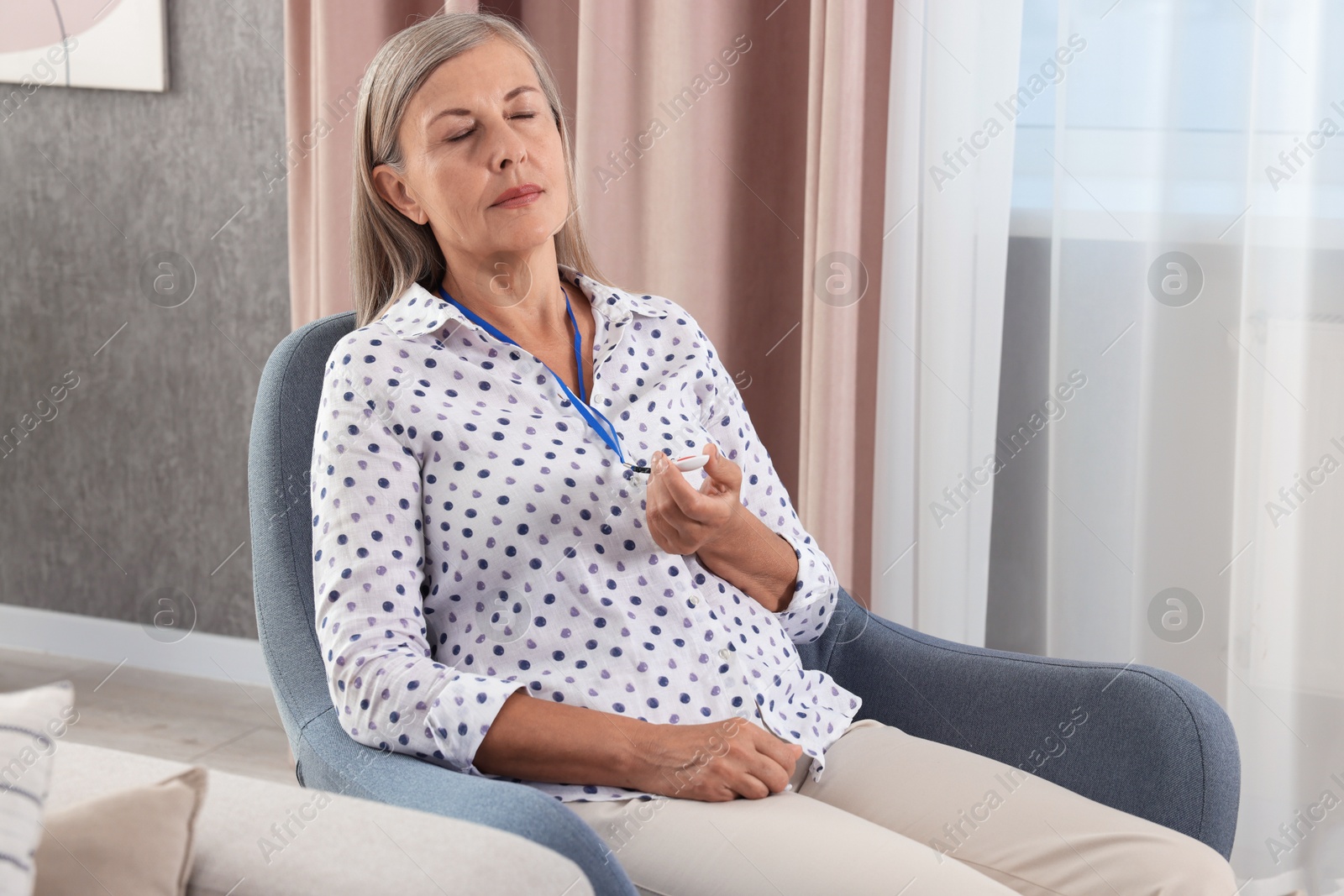 Photo of Senior woman with emergency call button at home