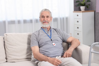 Senior man with emergency call button at home