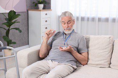 Senior man with emergency call button at home