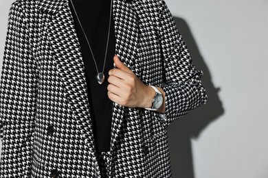 Photo of Woman in stylish suit on gray background, closeup