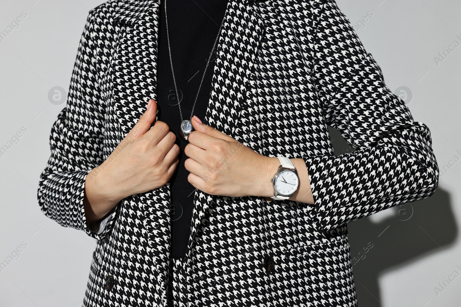 Photo of Woman in stylish suit on gray background, closeup