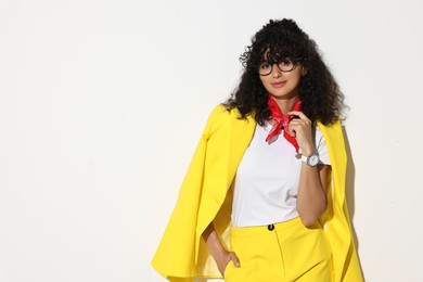 Beautiful young woman in stylish yellow suit on light background, space for text