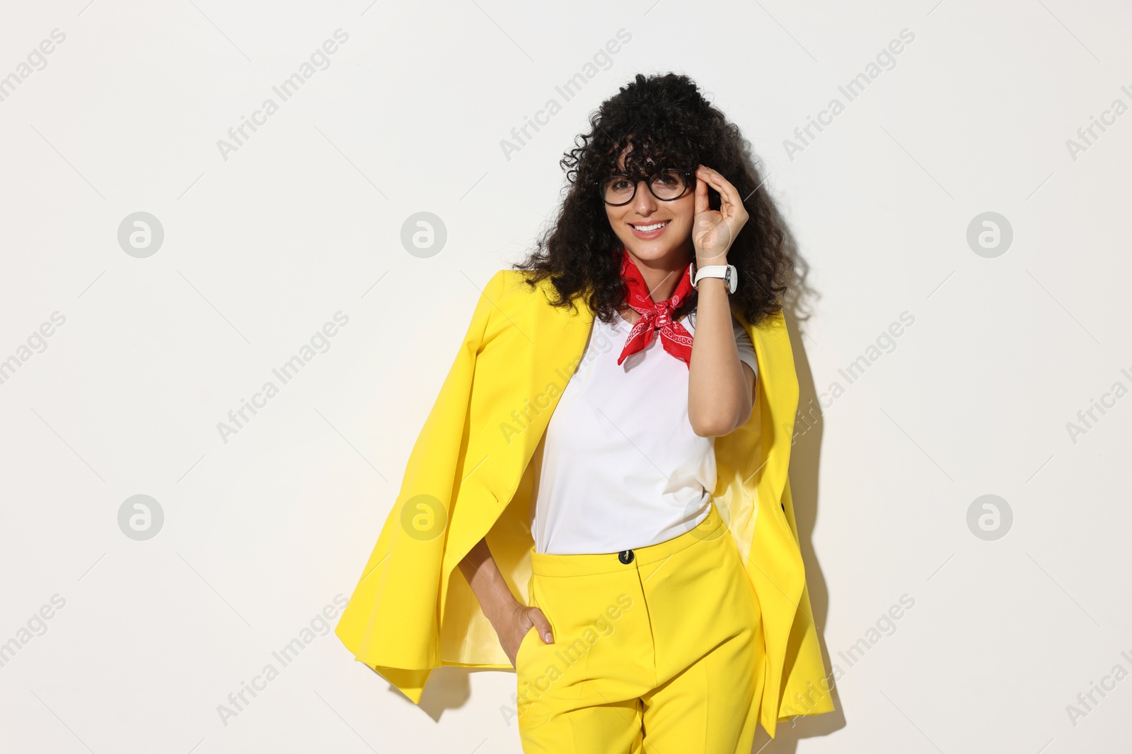 Photo of Beautiful young woman in stylish yellow suit on light background